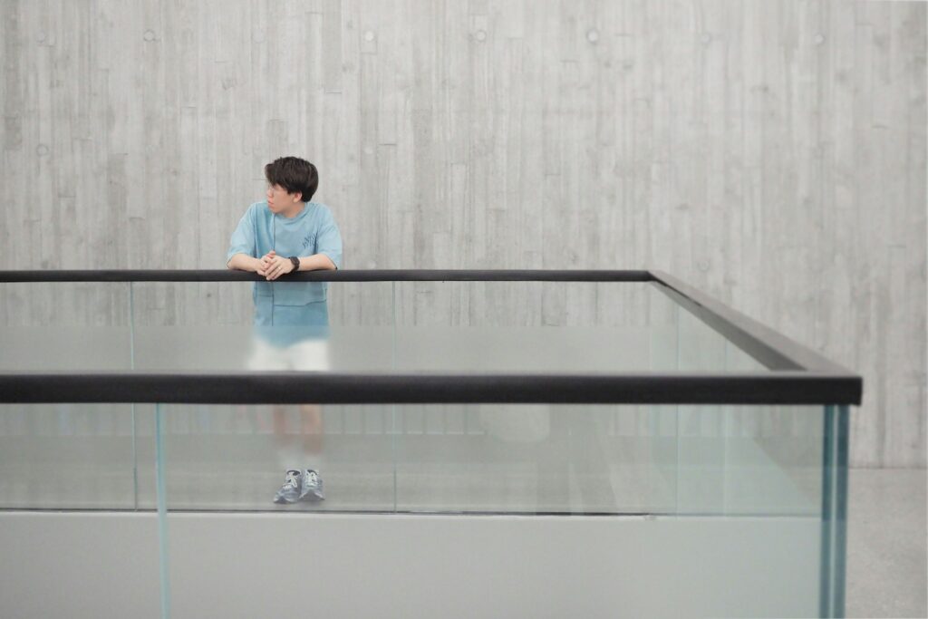 Young boy looking out from a glass enclosure