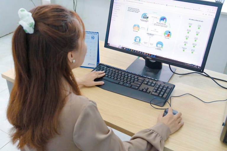 Young woman using desktop computer in office setting in Hanoi, Vietnam.