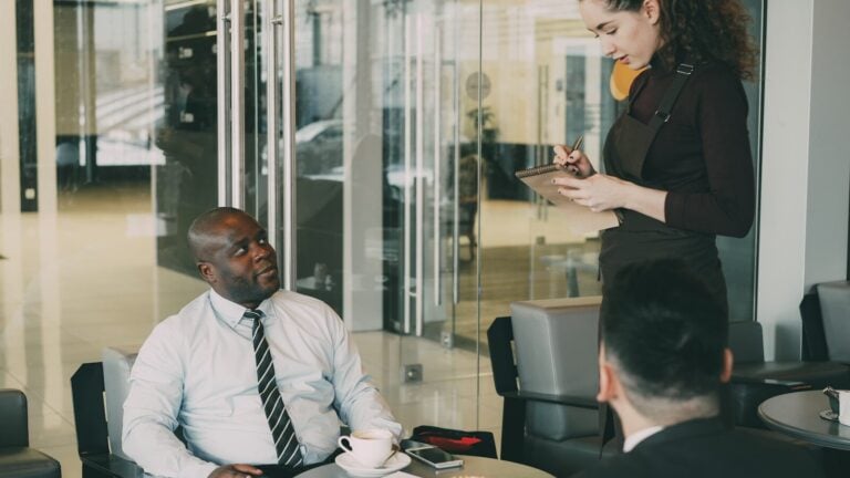 Business meeting with waiter taking notes