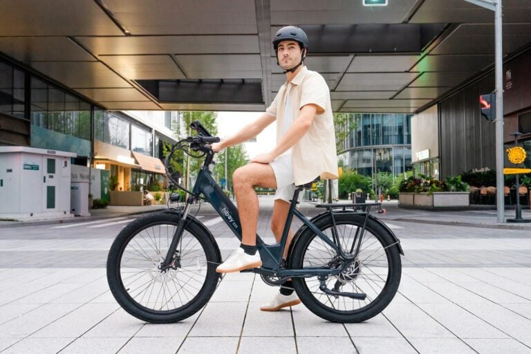 Man in helmet riding an electric bicycle outdoors.